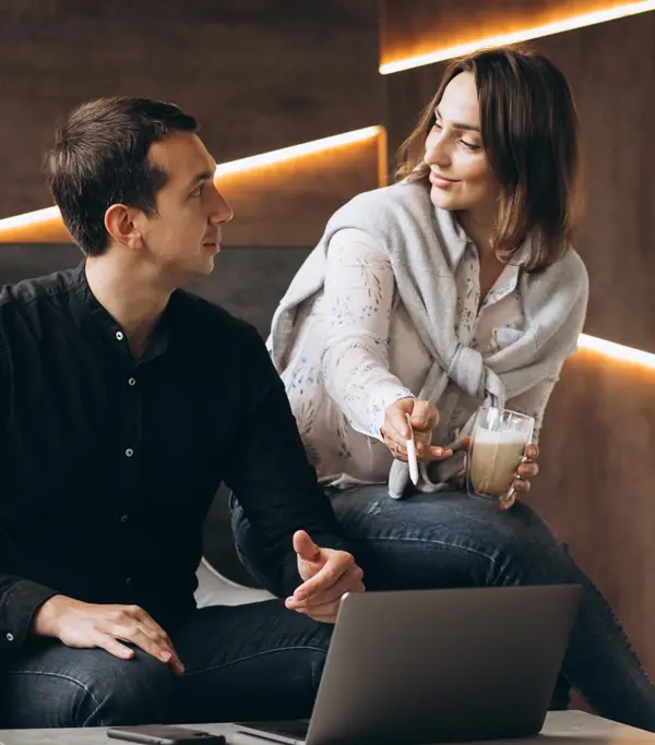 egy nő és egy férfi egyeztetnek egy laptop előtt